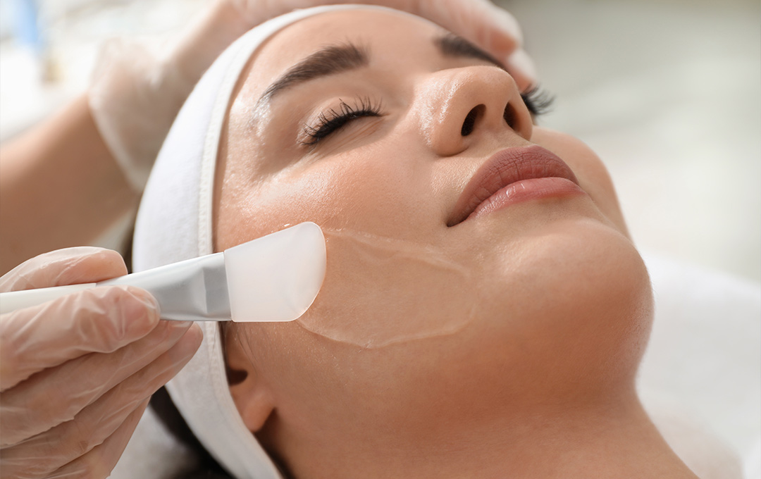 Woman lying down getting a chemical peel applied to her face during a BioRePeel for smoother texture and reduced lines and hyperpigmentation.