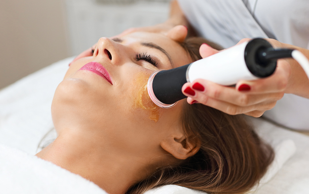 Woman lying down with her eyes closed, receiving a Glo2Facial treatment for a smooth, nourished, and radiant complexion.